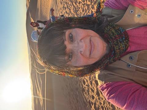 Selfie of a woman with a desert landscape in the background.