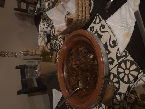       Traditional Moroccan dish with bread and a drink on a table.
  