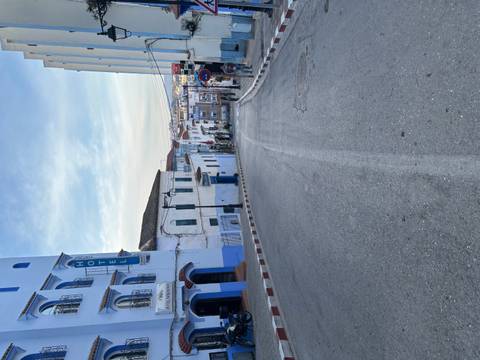 Street view of a quiet urban area with white and blue buildings.
