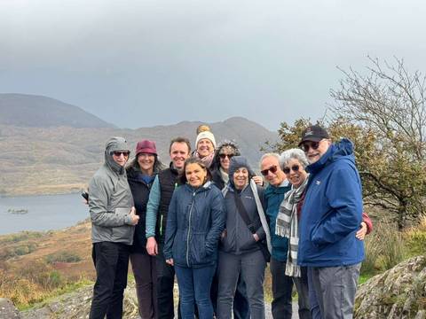 Group of hikers posing with mountains in the background