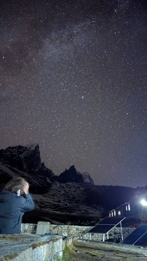 Night sky filled with stars over mountain silhouettes.