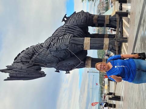       Person posing with the Trojan Horse replica.
  