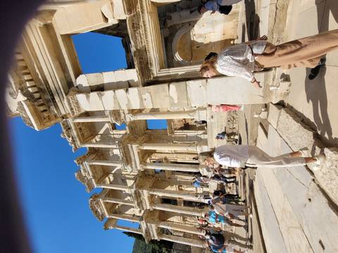 Crowd exploring the ancient ruins with distinctive columns.
