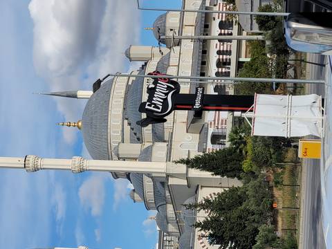 Mosque with a sign in front and clear blue sky.
