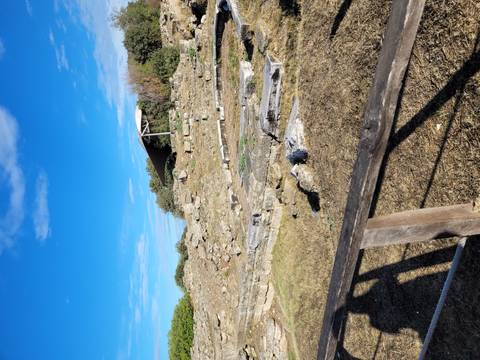       Ruins of ancient stone structures under blue sky.
  