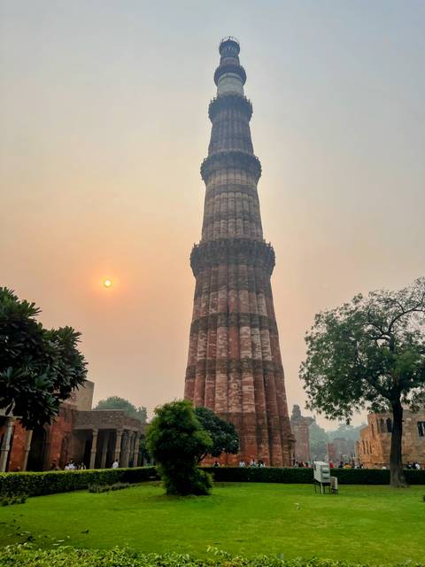 Qutub Minar in New Delhi with the sun setting.