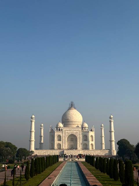 Long shot of the Taj Mahal under clear blue sky.