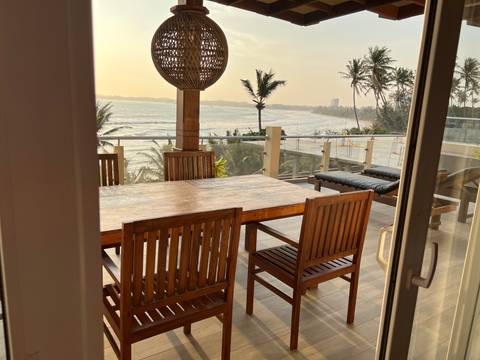 Ocean view from a deck with outdoor seating.