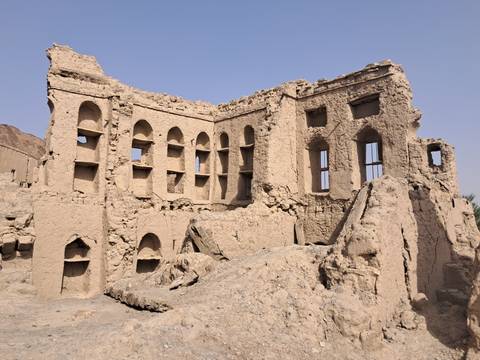 Ruins of an ancient building with arched windows.
