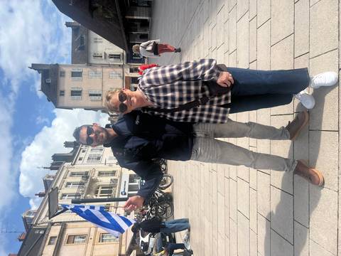 Two tourists posing together in a European city plaza.