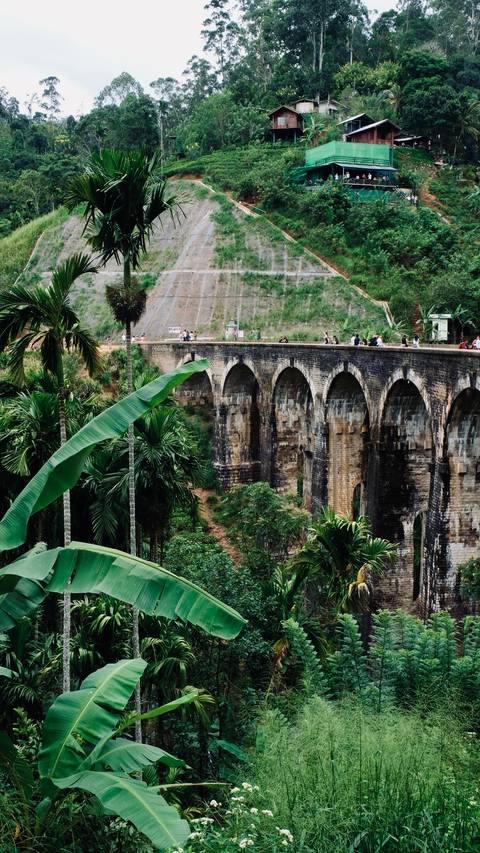 Scenic view of a stone bridge with tourists on top.