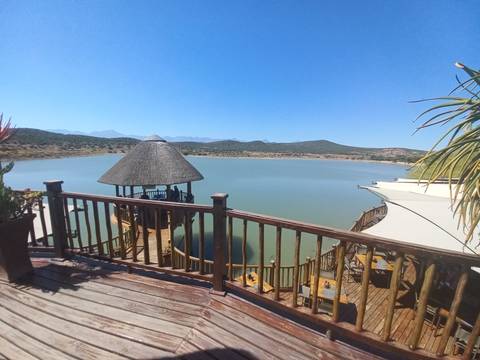 Lake view from wooden deck with thatched structures.