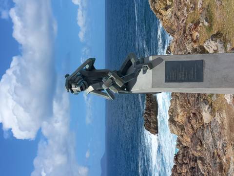       Sculpture of a figure overlooking the ocean.
  
