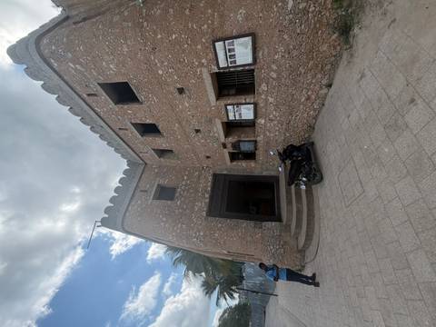 Rustic stone building with a scooter parked outside.