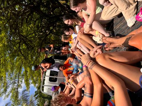 Group of people sitting in an open vehicle.