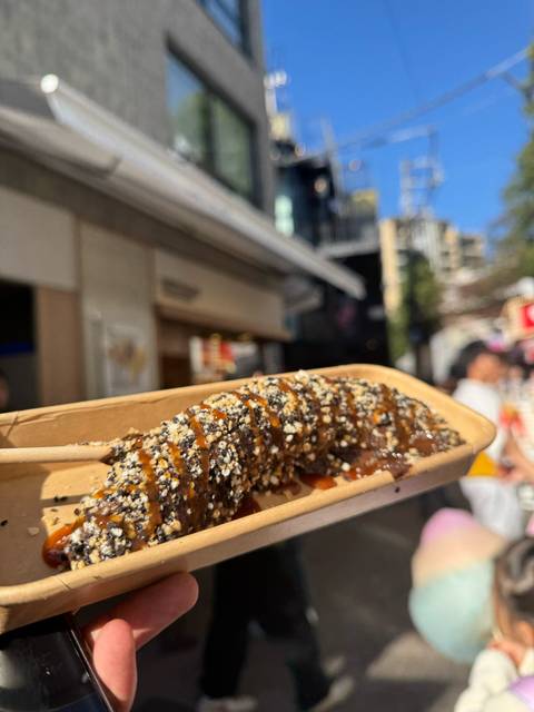 Close-up of a stick snack covered in chocolate sauce and nuts.
