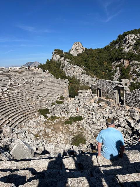 Ruins of an ancient amphitheatre on a hillside.