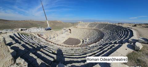 Roman Odeon theatre under restoration with construction equipment visible.