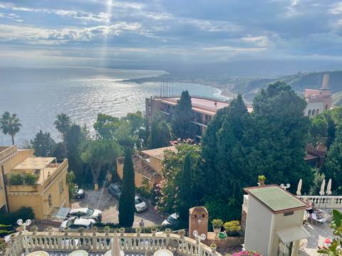       Scenic view of coastal town with sea and distant mountains
  