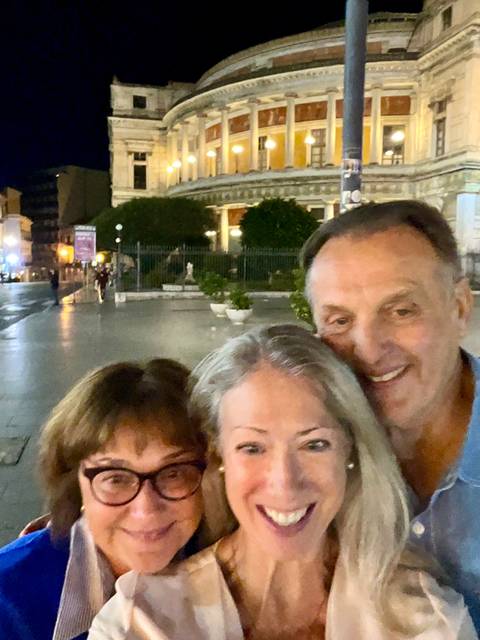       People taking a photo in a plaza at night
  