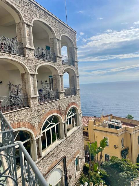 Balcony view of stone building overlooking the sea