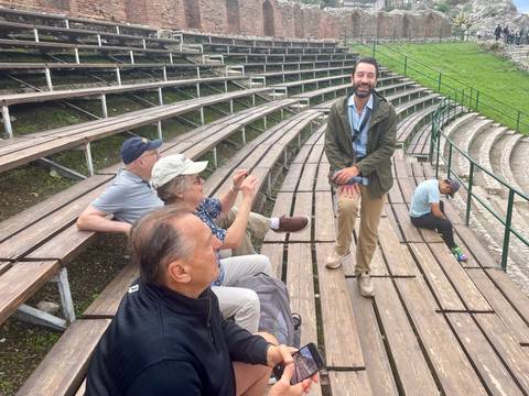       Group of people sitting on benches outdoors
  