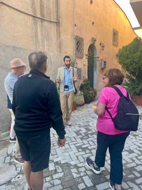       Tour guide speaking with a group in a narrow street
  