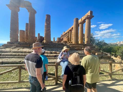       Group of people with a historic temple in the background
  