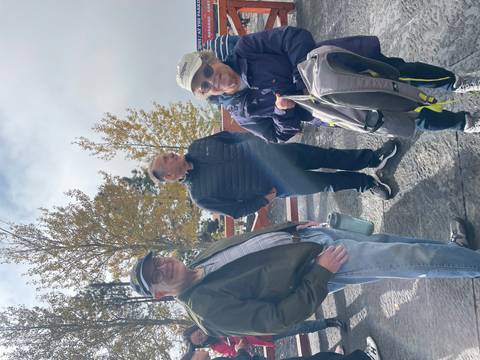       Group standing outdoors with trees and clouds
  