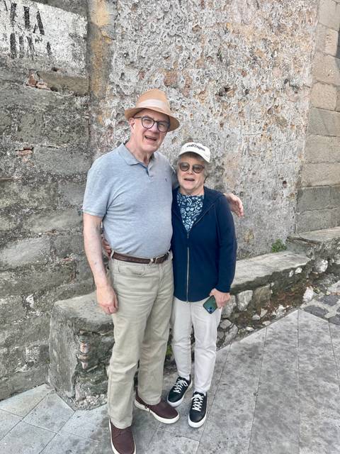 Couple posing against a stone wall