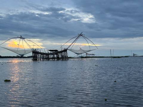       Fishing nets over water at sunset
  