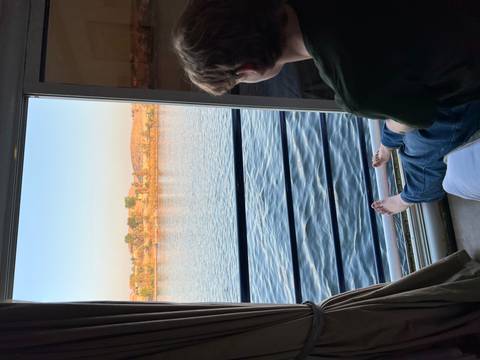       A person sitting by a window with a view of the Nile River.
  