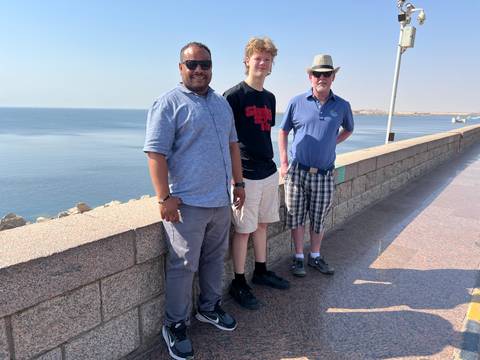       Three people on a viewing platform by the Nile River.
  