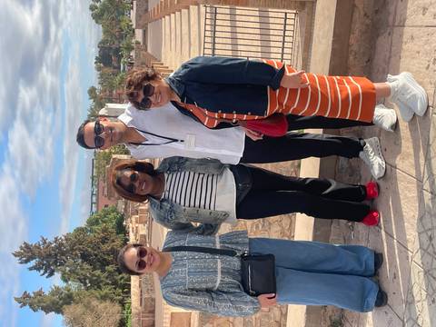 Group of tourists posing for a photo on a stone pavement.