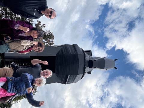 Group of people posing with a large Trojan horse structure.