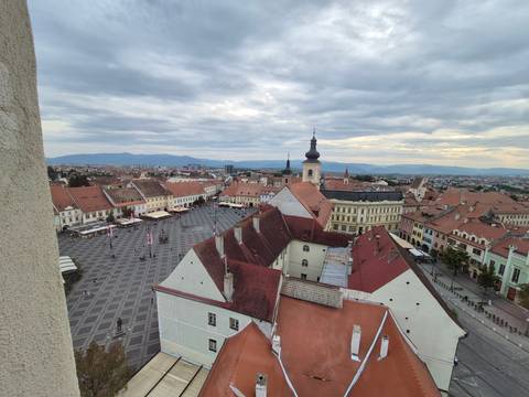       Aerial view of a historical city center with a prominent church tower.
  