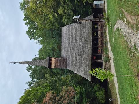 Rustic wooden church surrounded by trees.