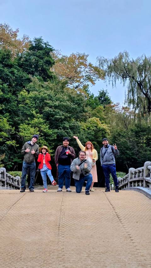 Group photo of people outdoors with greenery.