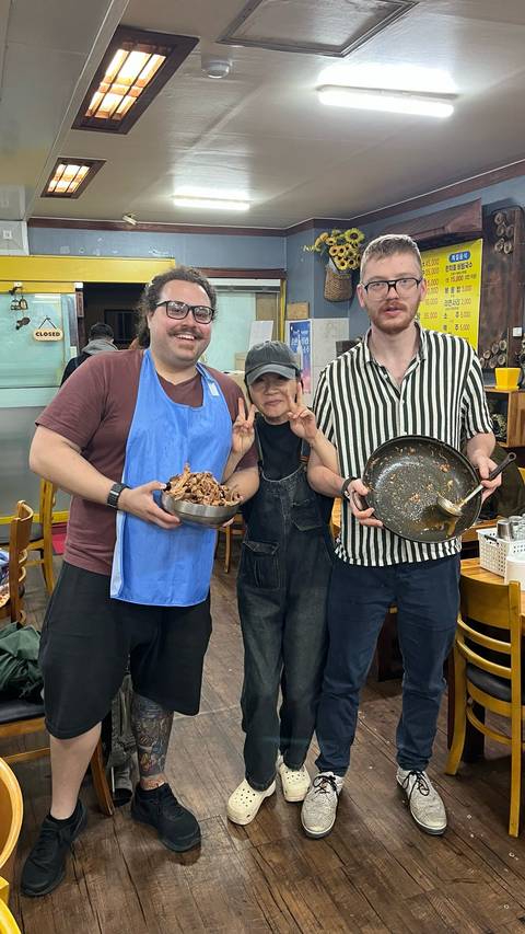Three people in a restaurant, proudly displaying empty dishes.