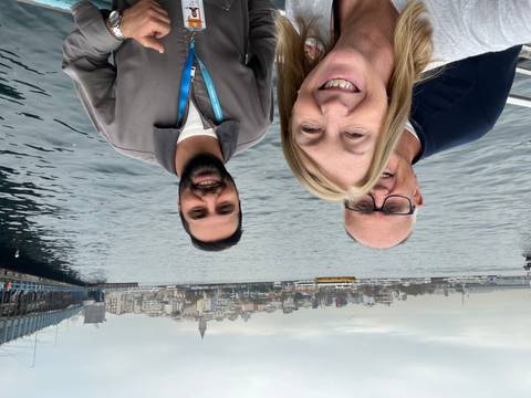 People on a boat with city skyline in the background.