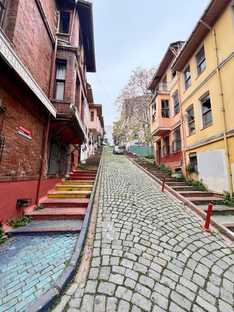 Colorful stairs on a steep cobblestone street.