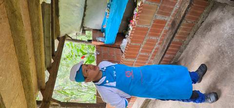       Person standing with arms crossed and wearing a blue apron.
  