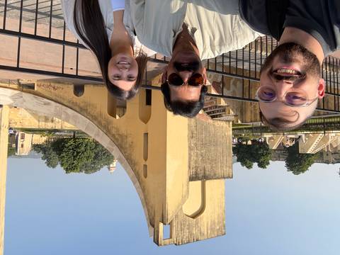 Three people taking a selfie in front of architectural structures.