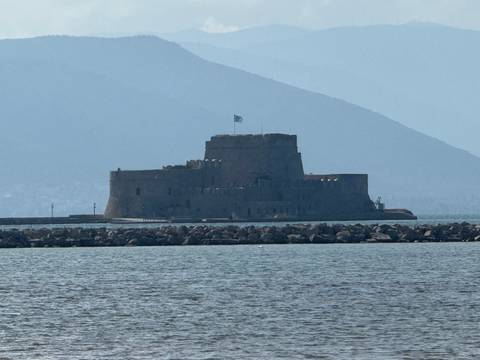       Silhouette of a fortress in the distance by the sea.
  
