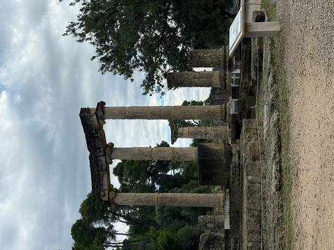      Ancient stone columns standing in a field.
  
