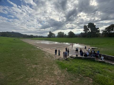       Tour group visiting ancient ruins in a field.
  