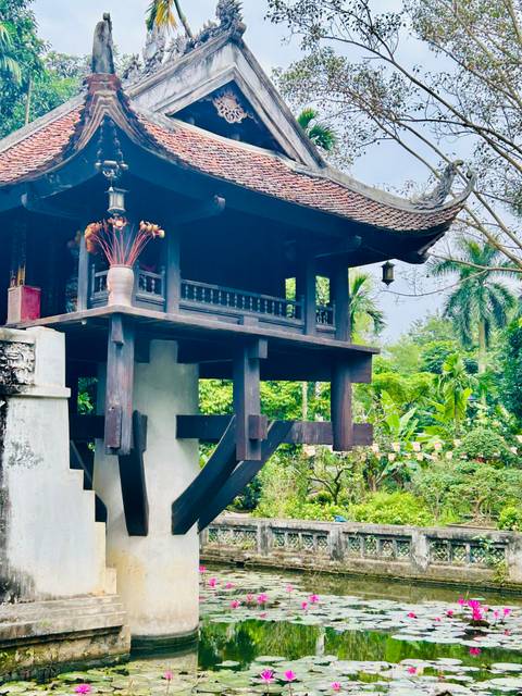 Historic wooden structure amidst lush greenery.