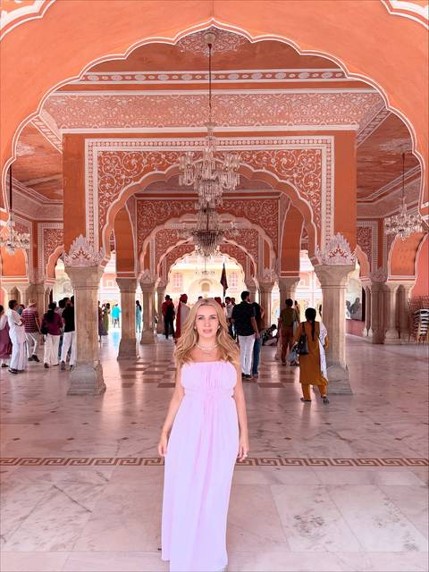 A woman standing in the beautifully decorated halls of the City Palace in Jaipur.