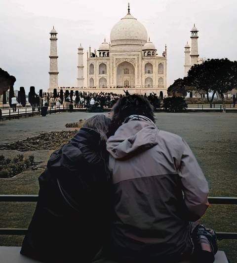 Two people sitting in front of the Taj Mahal.