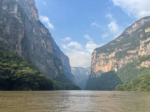 A picturesque river canyon with cliffs and greenery.